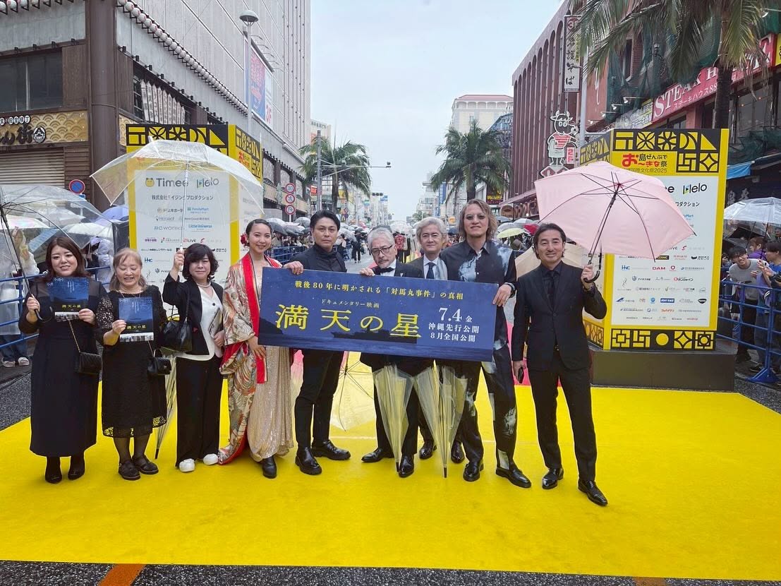 沖縄国際映画祭のイエローカーペットで、ドキュメンタリー映画『満天の星』の告知幕を掲げる出演者たち